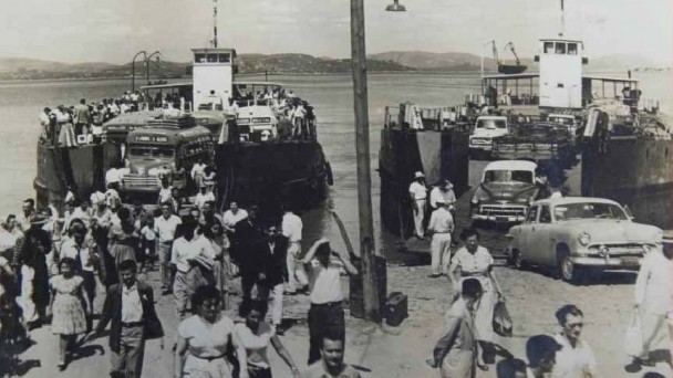 Travessia Porto Alegre - Guaíba. Foto em preto e branco, de 1947, mostrando o desembarque de passageiros a pé, carros e ônibus das barcas, no atracadouro do bairro Assunção, em Porto Alegre.