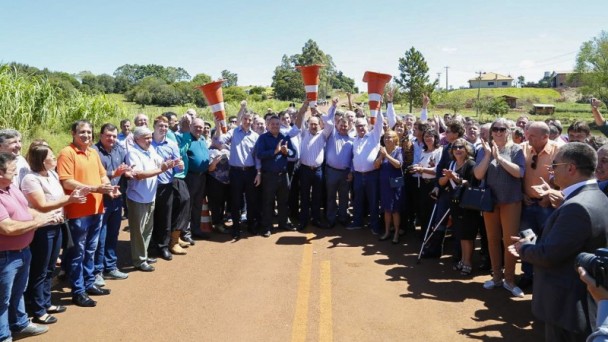 A foto mostra o governador José Ivo Sartori e demais lideranças políticas realizando o ato simbólico de erguer os cones de sinalização, oficializando a inauguração do acesso municipal a Eugênio de Castro.