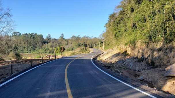 A foto mostra a pista da rodovia sem nenhuma imperfeição. Ao redor, vegetação.