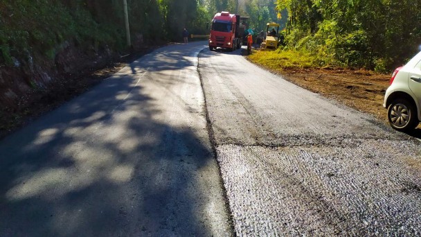 A imagem mostra máquinas trabalhando no recapeamento da pista