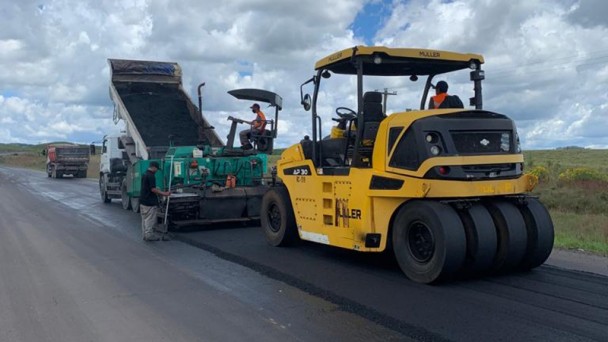 A imagem mostra máquinas realizando a compactação do novo asfalto