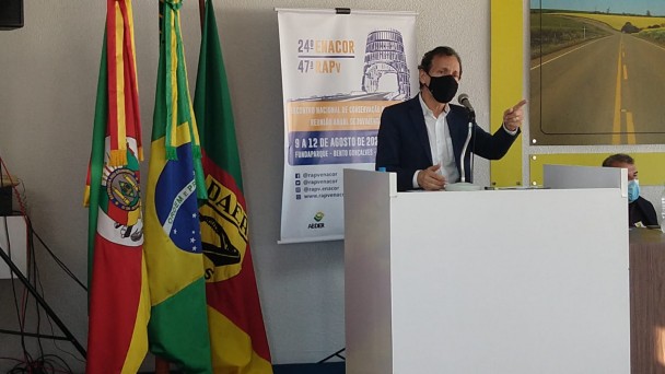 A imagem mostra o presidente da ABDER, Riumar Santos, durante seu discurso