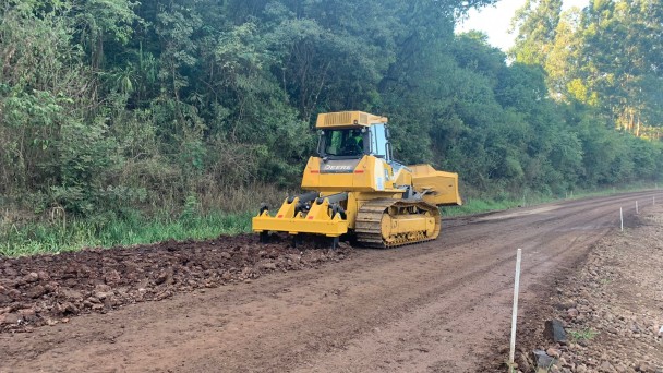 A imagem mostra as máquinas trabalhando na estrada de chão