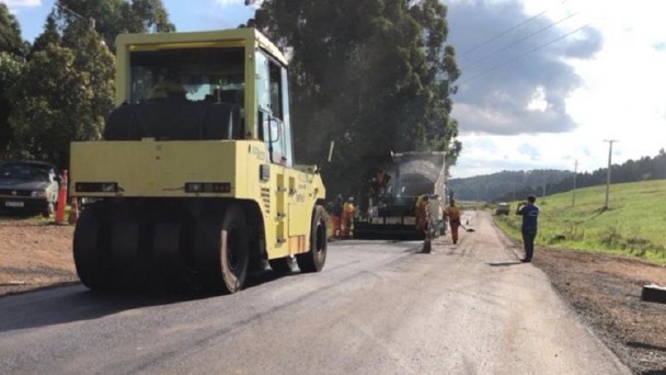 Imagem mostra máquinas durante a compactação do novo asfalto