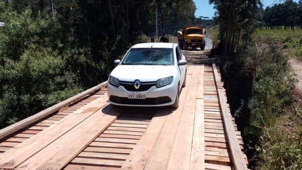 Imagem mostra veiculo atravessando ponte de madeira