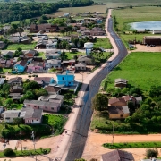 A foto aérea mostra um trecho já pavimentado do acesso a Amaral Ferrador.