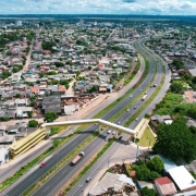 Imagem área da ERS-118 onde aparece a rodovia, passarela de pedestres, casas e prédios do entorno.