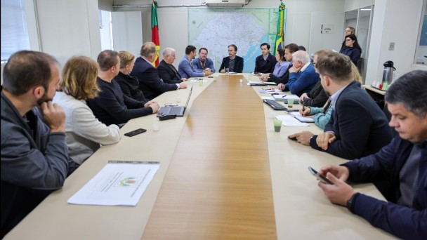 A foto mostra prefeitos do Vale do Taquari reunidos em uma mesa com o secretário Juvir Costella e o diretor-geral do Daer, Luciano Faustino
