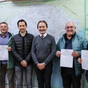 Imagem com seis pessoas em frente a mapa do Rio Grande do Sul.