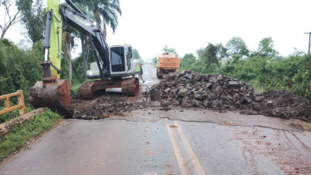 Imagem mostra pavimento com pedras &agrave; direita e m&aacute;quina na esquerda.